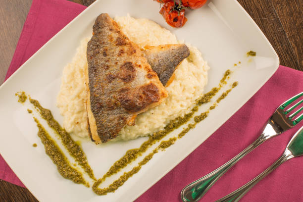 istock Grilled trout with risotto, tomatoes, and pesto 638631020