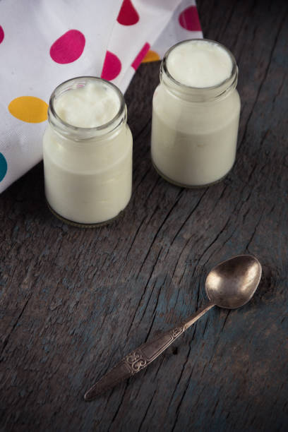 istock jars with white yogurt and spoon on the wooden background 638631044