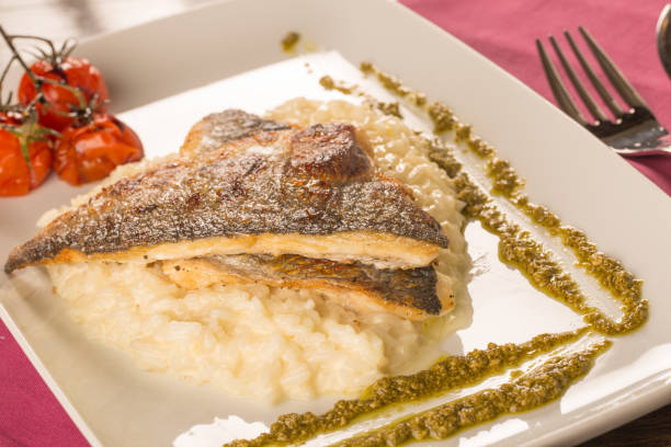 istock Grilled trout with risotto, tomatoes, and pesto 638631176