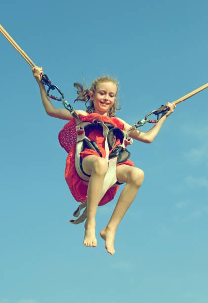 istock Little girl on bungee trampoline with cords. Place for text. 638631584