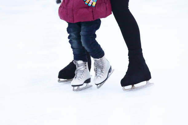 istock child and the man is skating on the ice 638634722