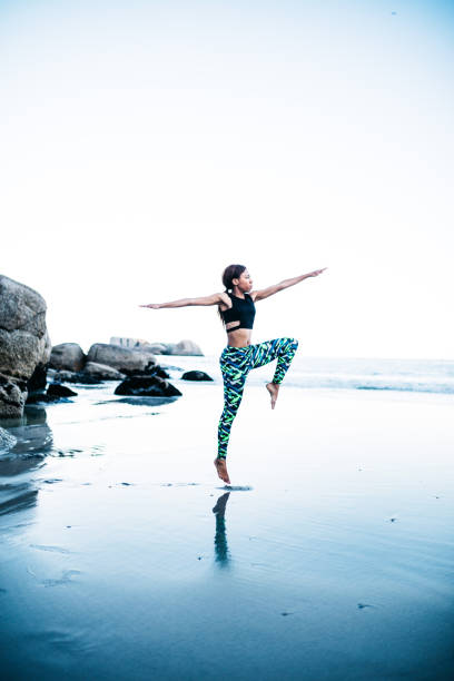 istock Young african women doing yoga pose on beach 638634912