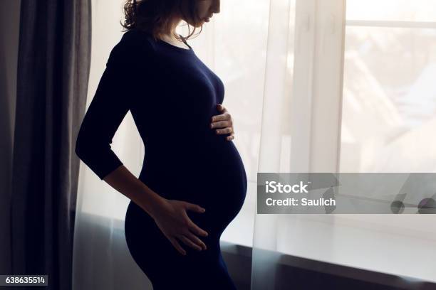 Young Pregnant Girl In A Blue Bodycon Dress Standing Stock Photo - Download Image Now