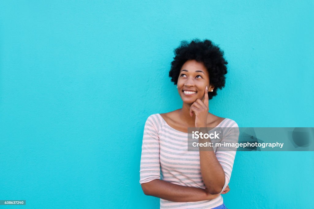 Beautiful young african woman smiling and thinking Portrait of a beautiful young african woman smiling and thinking Women Stock Photo