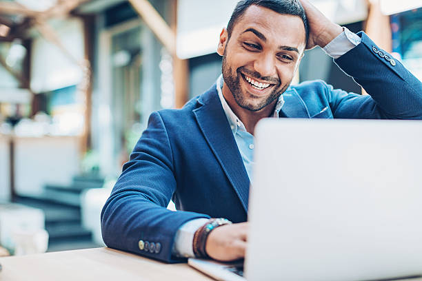 Excited businessman Young Middle Eastern ethnicity businessman looking at his laptop with happiness and excitement. middle eastern culture stock pictures, royalty-free photos & images