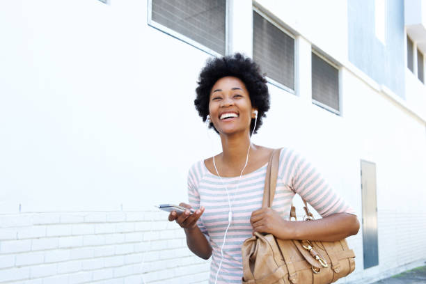istock Woman walking on sidewalk with mp3 player and purse 638640634
