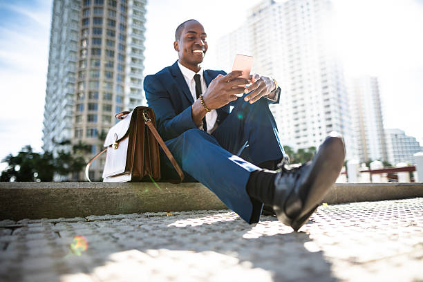 businessman texting in miami sitting on the park