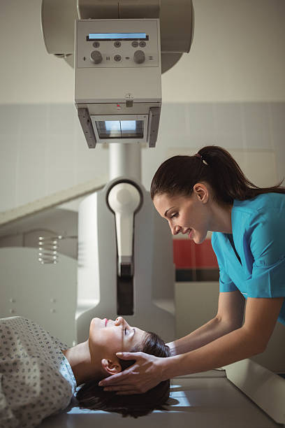 paciente femenina sometida a una prueba de rayos x - x ray image radiologist examining using voice fotografías e imágenes de stock