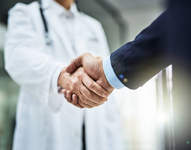 Health is wealth Cropped shot of a doctor shaking hands with a businessman doctor stock pictures, royalty-free photos & images