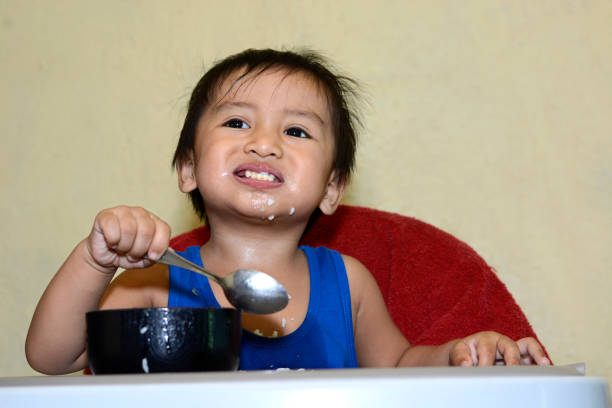 istock 1 year old baby boy learning to eat alone smiling 638647754