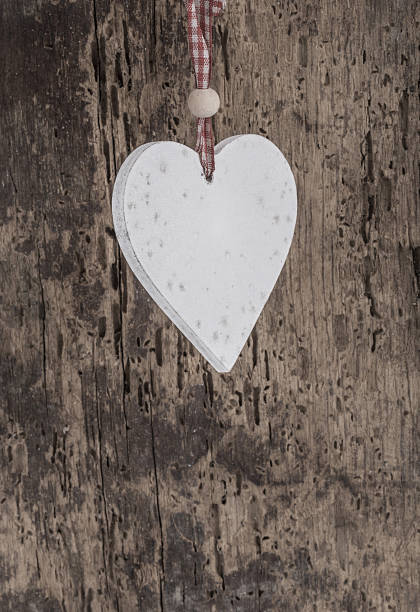 istock hanged white heart against wooden background 638650270