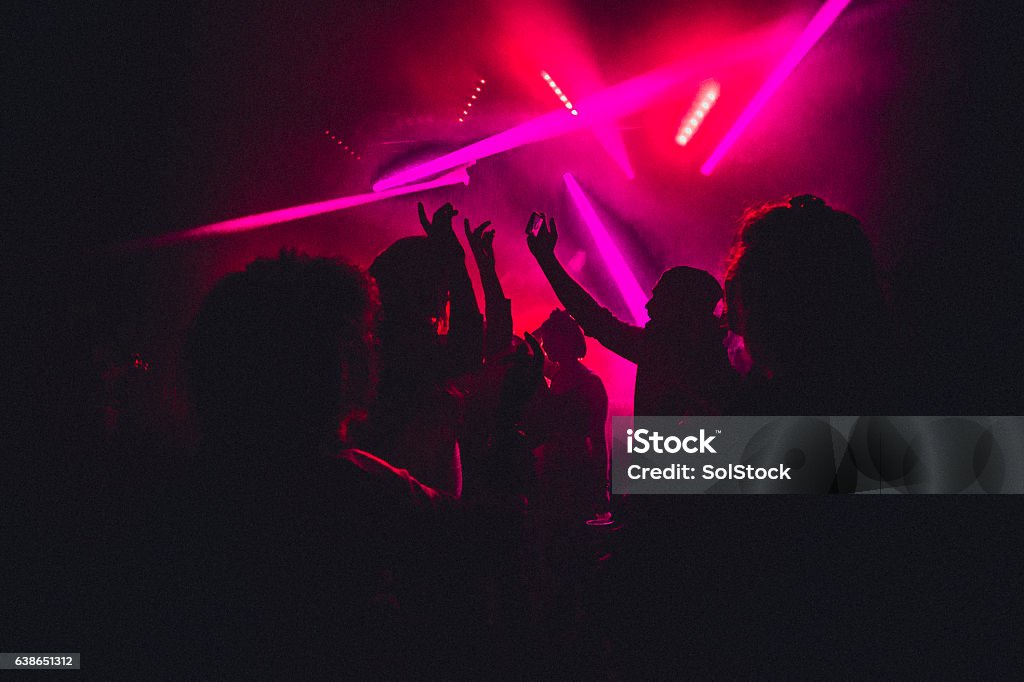 Dancing the Night Away People dancing in a nightclub with smoke machines and strobe lighting around them. Nightclub Stock Photo
