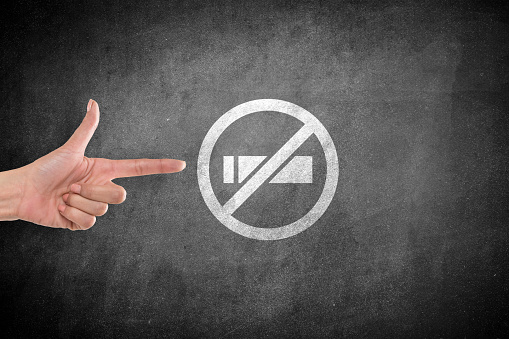 woman agrees to no smoking icon with pointing gesture in front of blackboard