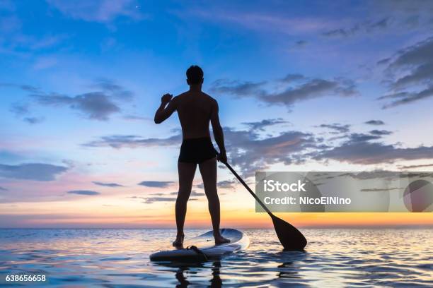 Silhouette Of Stand Up Paddle Boarder Paddling At Sunset Sea Stock Photo - Download Image Now