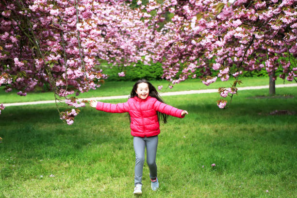 Happy beautiful girl in blossom park