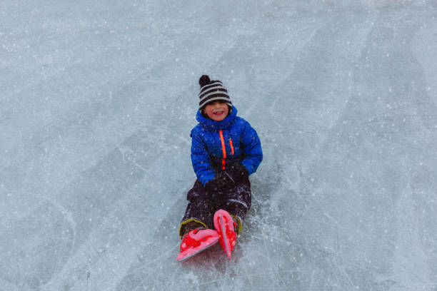 istock happy little boy learning to skate in winter 638657298