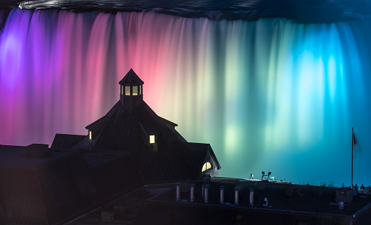 Niagara Falls illuminated at night. The Canadian waterfalls are visible and illuminated with colors.