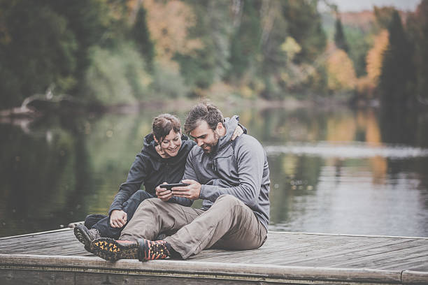 istock Adult Couple Using Smart Phone in Nature 638659978