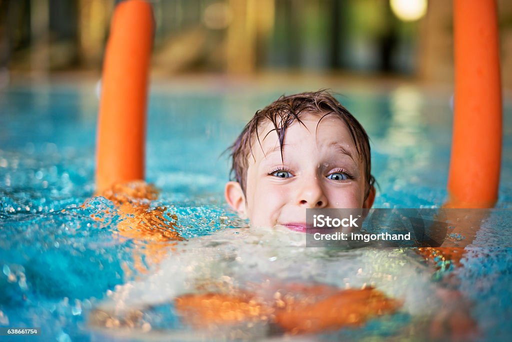 Petit garçon apprentissage se baigner avec piscine à nouilles - Photo de Natation libre de droits