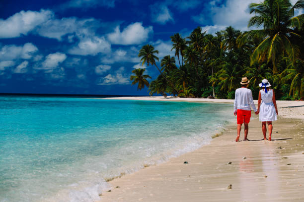 istock happy loving couple walking on beach 638661784