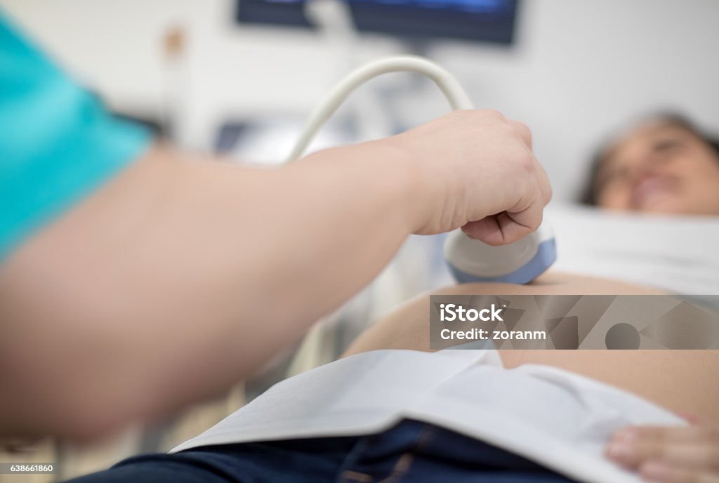 Having ultrasound scan Pregnant woman having ultrasound scan, focus on doctor's hand holding transducer 25-29 Years Stock Photo
