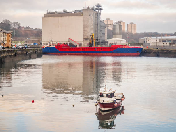 Small ship unloading cargo of grain in harbor of Kirkcaldy Scotland stock photo