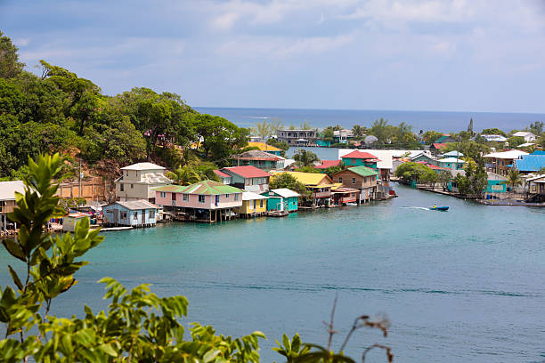 Series:Honduran island of Roatain in the Caribbean *3 logo rule. Scenic view of a seaside village on  Roatain, which is part of the Bay Islands of Hondouras. It is the largest of the Bay Islands and an eco-tourism destination. Colorful wooden stilt homes dot the landscape. Taken with Canon 5D Mark lV. stilt house stock pictures, royalty-free photos & images