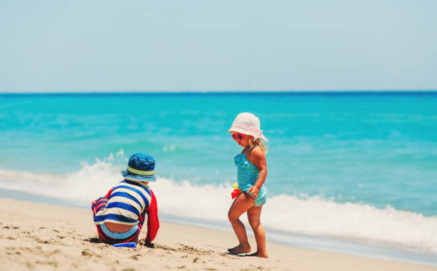 istock kids play with sand on summer beach 638664278