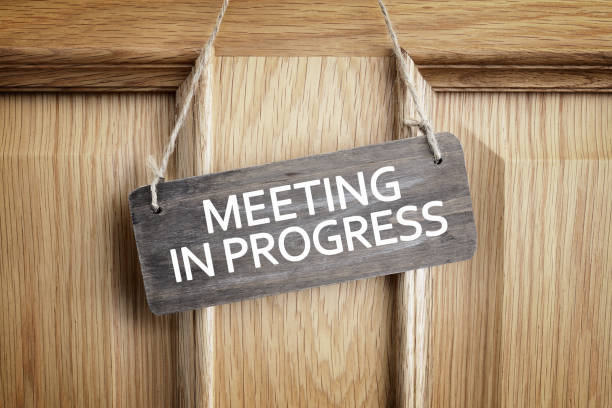 istock Meeting in progress sign on office door 638665656
