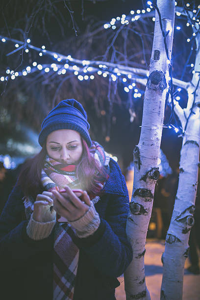 istock Beautiful young woman using her mobile phone at night. 638666950