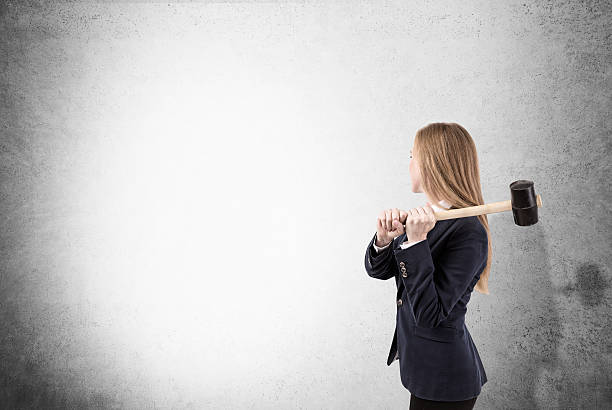 istock Woman is smashing concrete wall with sledgehammer 638667768