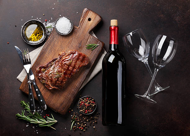 bife de carne de costela grelhado com vinho tinto, ervas e especiarias - rib eye steak beef cutting board meat - fotografias e filmes do acervo