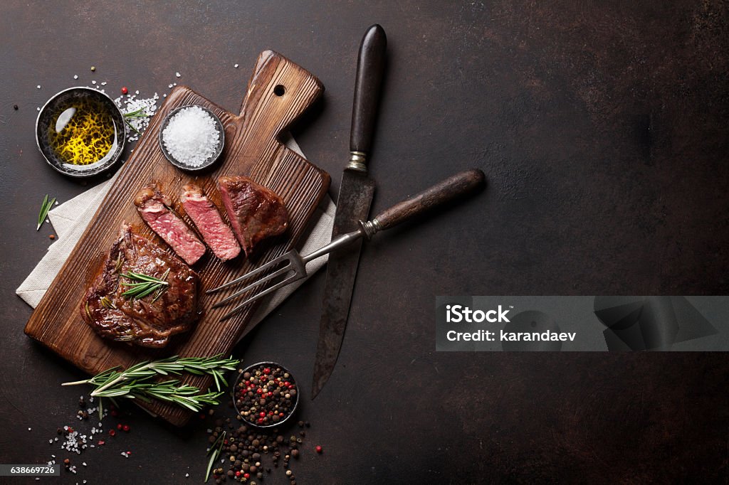 Grilled ribeye beef steak, herbs and spices Grilled ribeye beef steak, herbs and spices. Top view with copy space for your text Meat Stock Photo