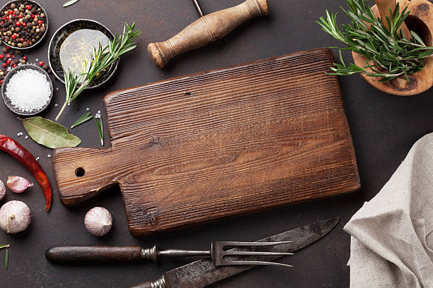 tavolo da cucina con erbe aromatiche, spezie e utensili - garlic cooking oil cutting board horizontal foto e immagini stock