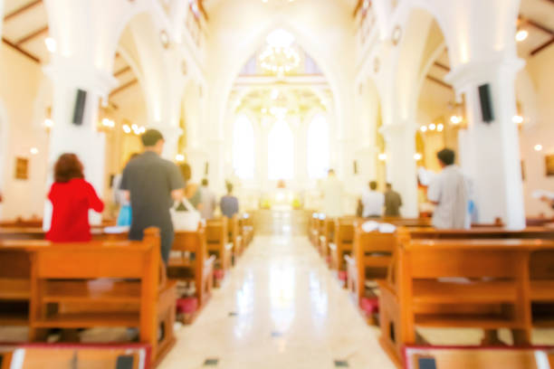 sfocata messa cristiana pregando all'interno della chiesa - cattolicesimo foto e immagini stock