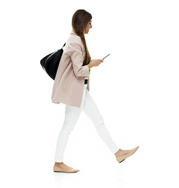 istock Smiling woman using phone and walking 638672390