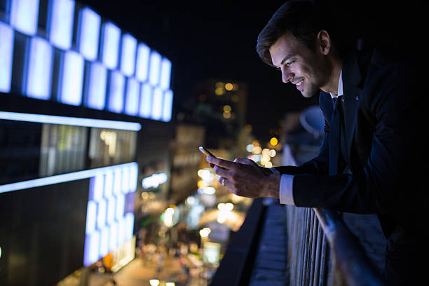 istock Businessman using smart phone above night city 638674970