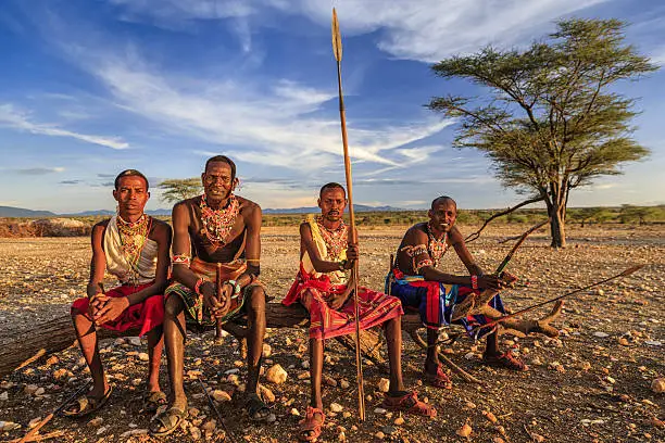 African warriors from Samburu tribe resting on savanna, central Kenya. Samburu tribe is one of the biggest tribes of north-central Kenya, and they are related to the Maasai.