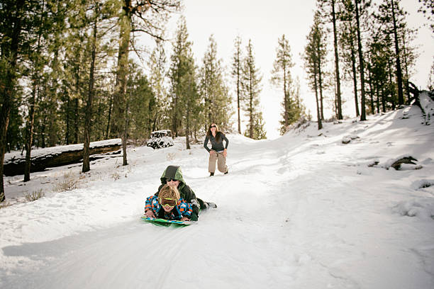 istock two boys ride together on a sled 638677798
