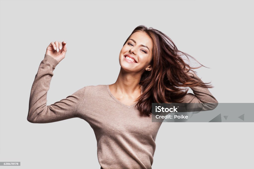 Beautiful emotional woman having fun Cute young girl with arms raised dancing and laughing and enjoying life Women Stock Photo