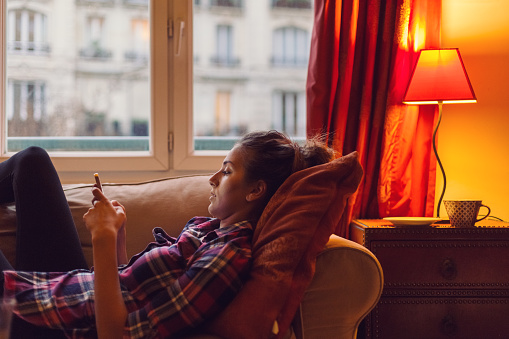 Relaxed woman at home text messaging