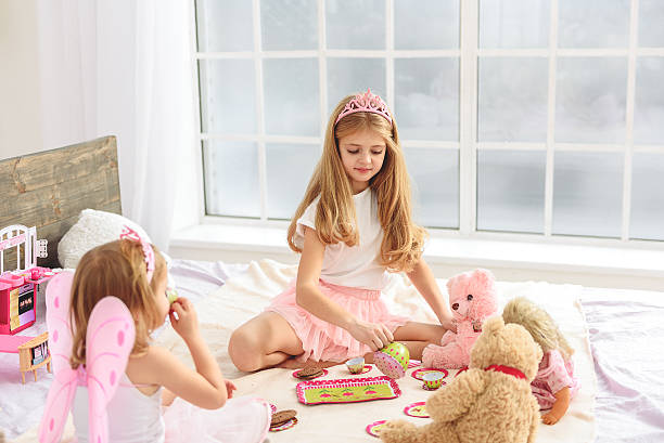 istock Cute sisters having tea party in bedroom 638681086