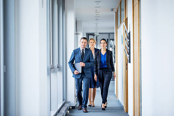 istock Corporate professionals walking in office corridor 638683654