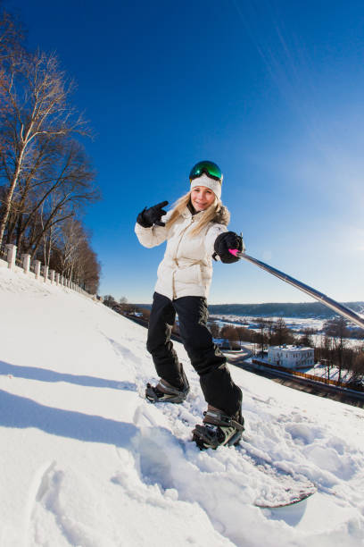 istock Young woman with the snowboard shooting a selfie 638685466