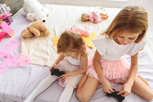 istock Joyful girls playing console in bedroom 638685482