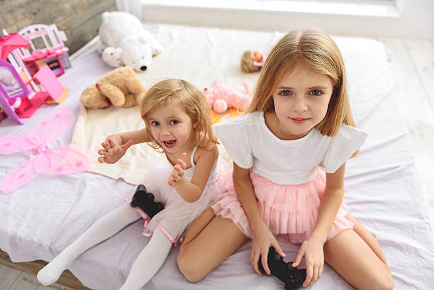 istock Carefree two sister having fun with videogame 638685588