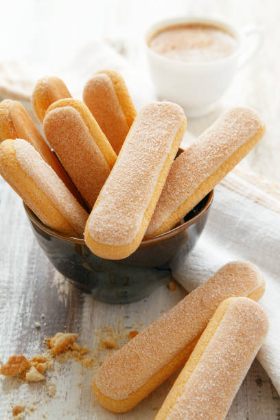 Ladyfingers in a bowl, coffee in the background. Tiramisu ingredients stock photo