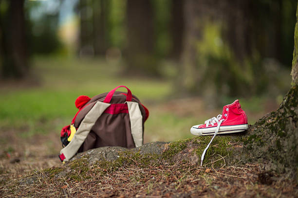 Child's backpack and shoe left behind in a wooded park