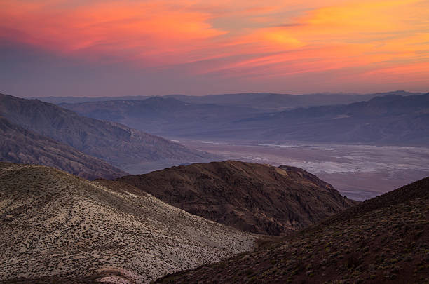 View down into Death Valley during a bright red and orange sunset.