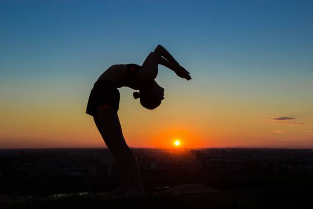 istock Woman practicing yoga at sunset - drop back, wheel pose 638696588